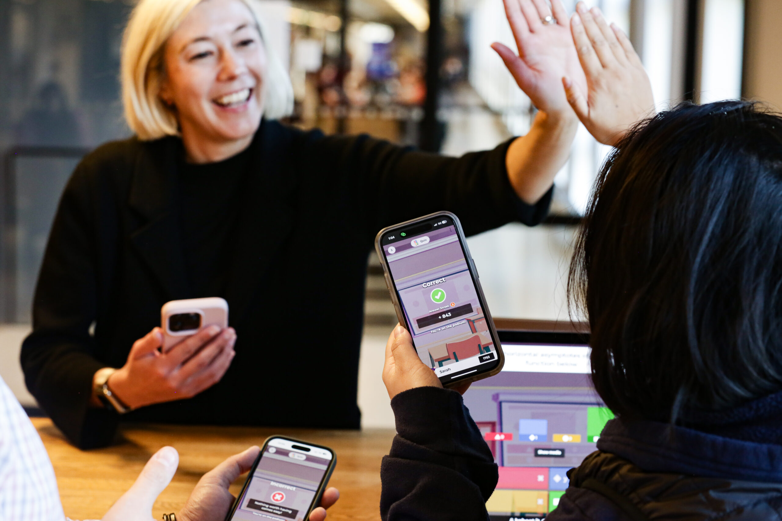 Two people high-fiving while playing a kahoot